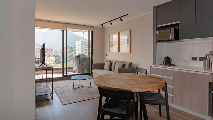 Sala comedor y cocina de concepto abierto iluminada con vista panorámica en apartamento moderno