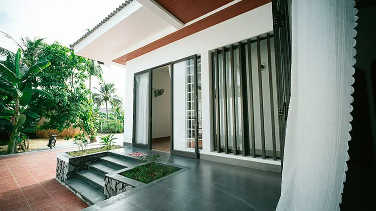 Fachada y entrada principal de casa moderna en venta con porche y ventanales