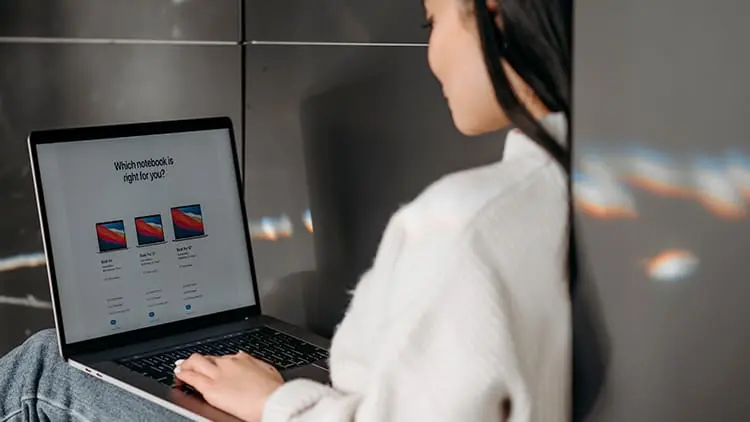 Mujer revisando el portal inmobiliario en laptop para buscar inmuebles en Venezuela